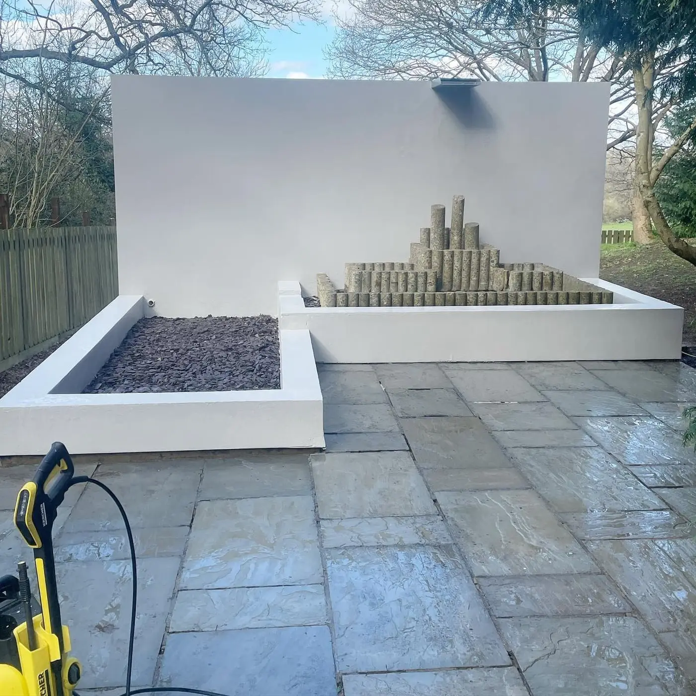 Freshly rendered garden wall and pressure-washed paving after exterior property care works